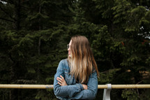 a woman with crossed arms standing on a bridge
