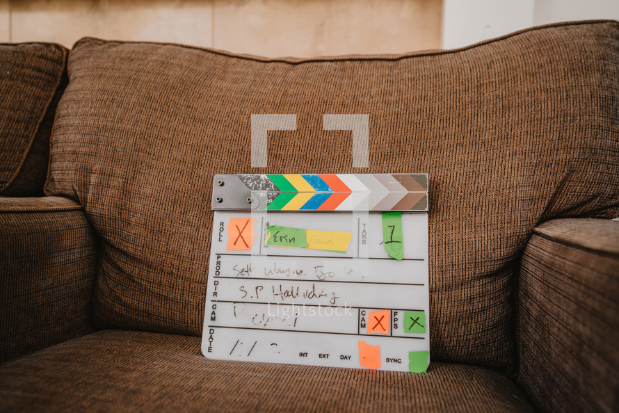Film slate on a couch on set