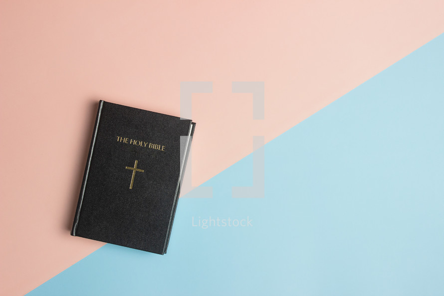 a Bible on a pink and blue background 