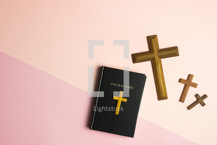 Bible and crosses on a peach and pink background 