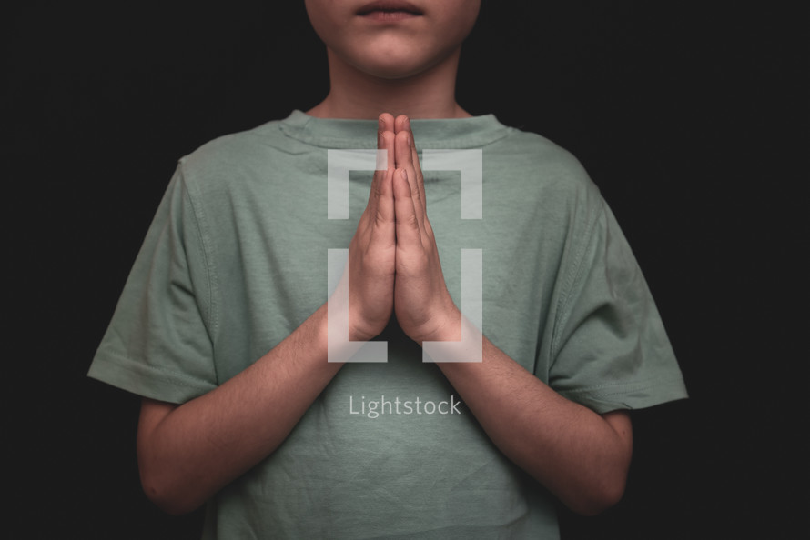 a boy with praying hands 