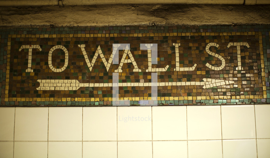 Mosaic tile direction sign.