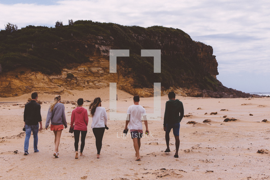 friends walking on a beach 