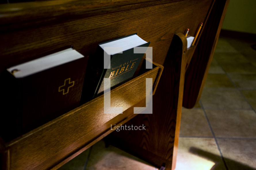 Bible and hymnals in the back of church pews 