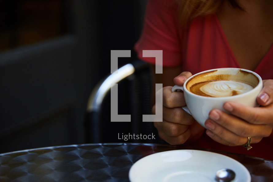 a woman holding a latte 