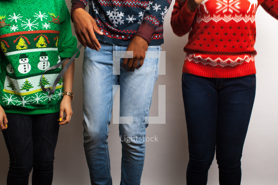 torsos of friends in an ugly Christmas sweaters