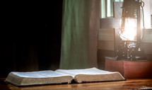 open Bible and lantern in the window 