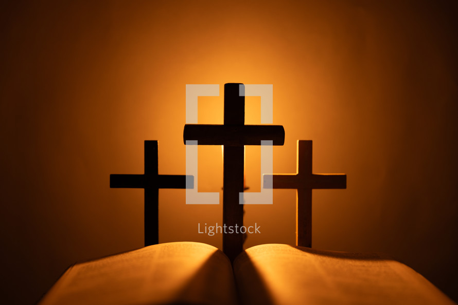 Candlelight photo of a Bible and crosses