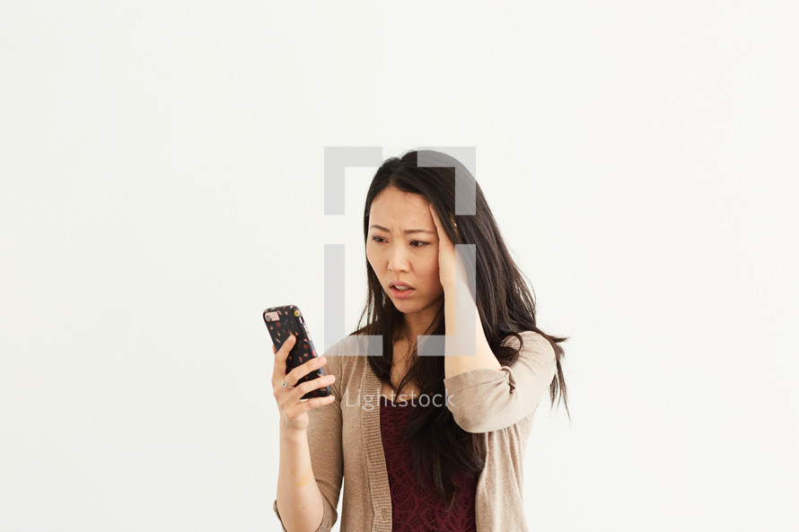 a stressed woman looking at a cellphone 