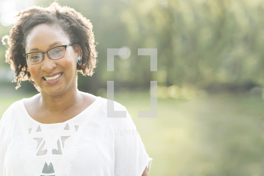 African-American woman's smiling face standing outdoors 
