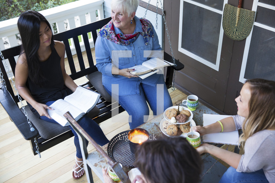 Women on a porch having a Bible study.