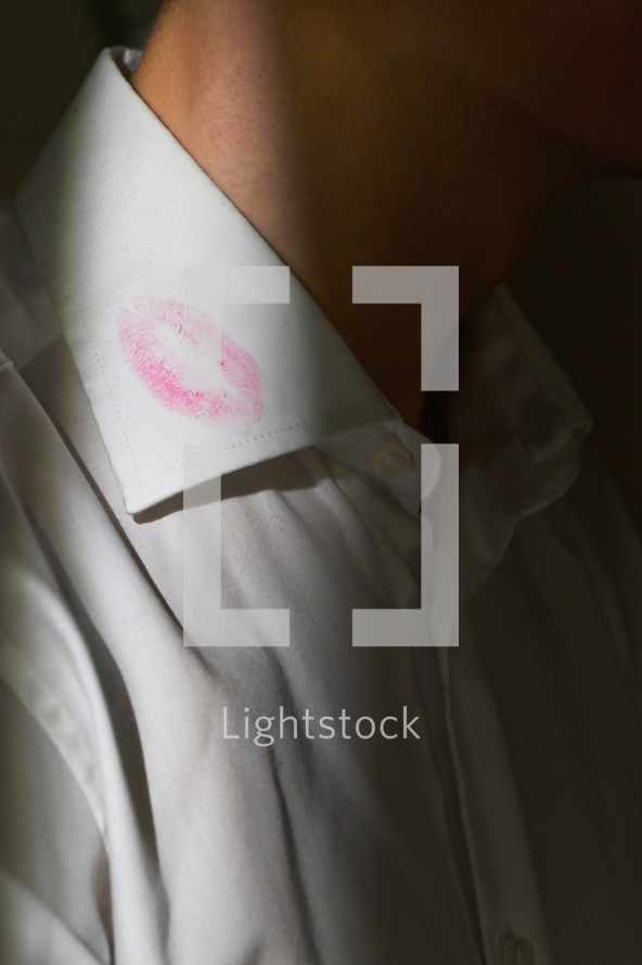 a lipstick stain on a man's white dress shirt collar 