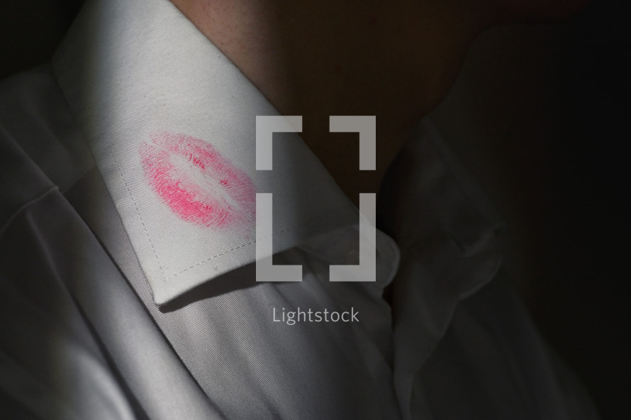 Lipstick marks on the collar of a men's white dress shirt