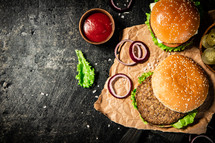 A burger on a stone board on a table. On a black background. High quality photo