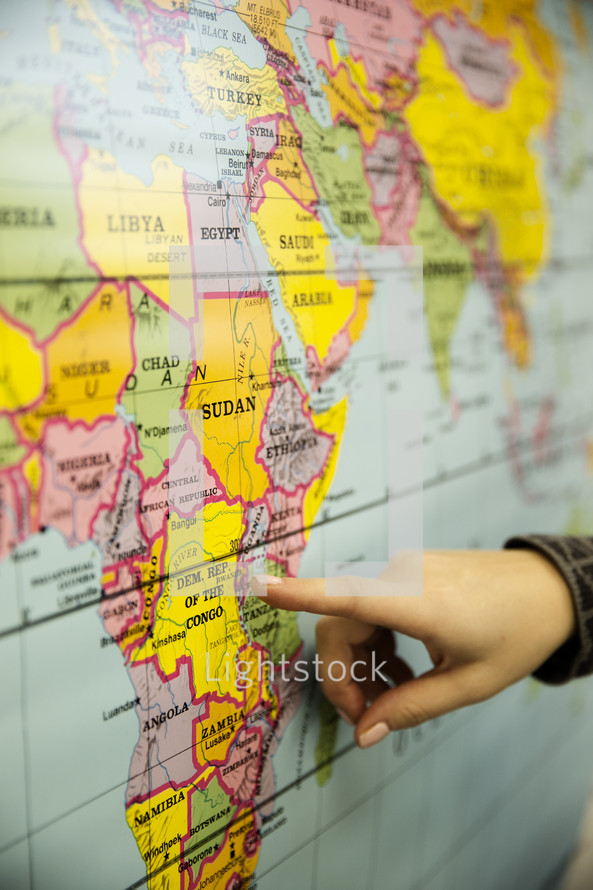finger pointing to a map of Africa 