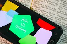 Join Us Online on a smartphone screen on a Bible 