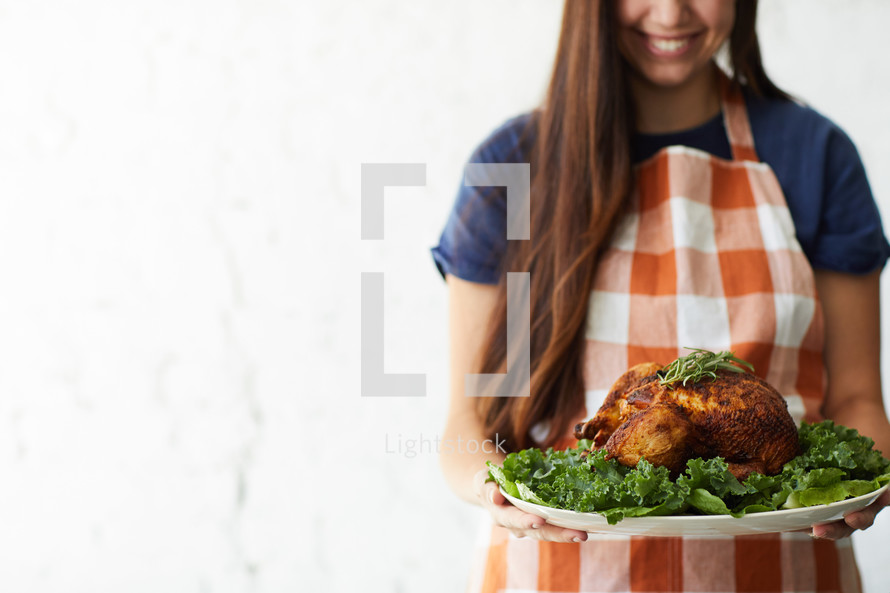 a woman holding a thanksgiving turkey 