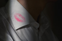 Lipstick marks on the collar of a men's white dress shirt