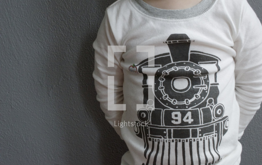 A child wearing a shirt with a train on the front.
