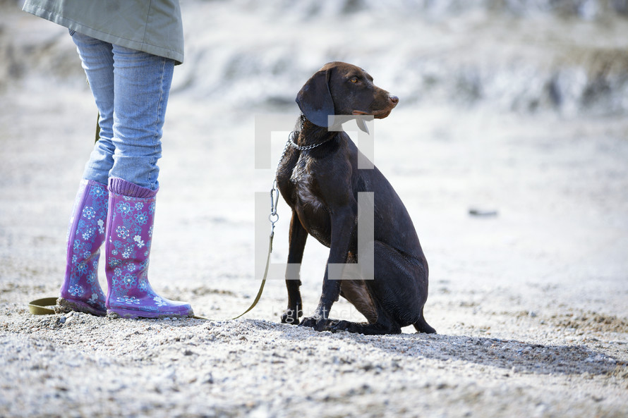 a woman in rain boots and her dog 