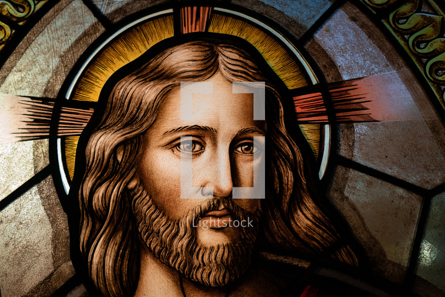 Close up of a stained glass window of Jesus's face and eyes,