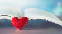 felt heart on the pages of an open book