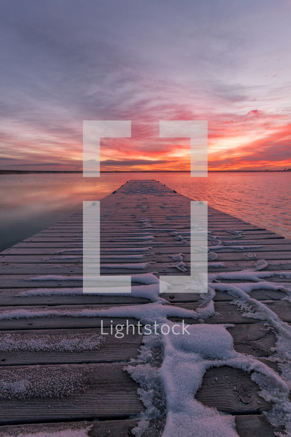 snow on a pier at sunset 