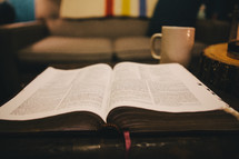 An open Bible on a coffee table. 