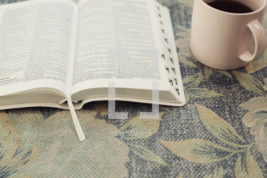 open Bible on floral fabric and coffee cup 