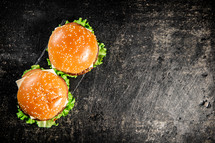 A burger on a stone board on a table. On a black background. High quality photo