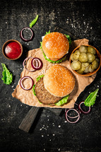 A burger on a stone board on a table. On a black background. High quality photo