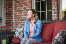 a woman sitting quietly on a porch 