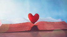 felt heart on the pages of an open Bible 