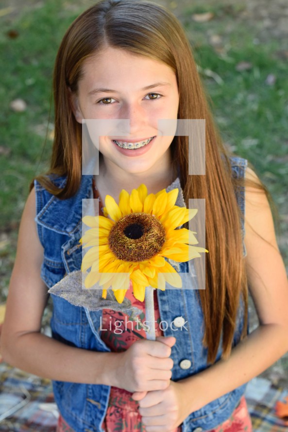 teen girl holding a sunflower 