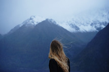 woman looking out at snowy mountains 