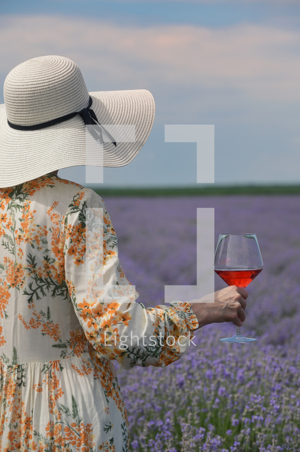 woman in a field of lavender holding a wine glass 