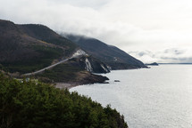 a road along a mountain overlooking a coastline 