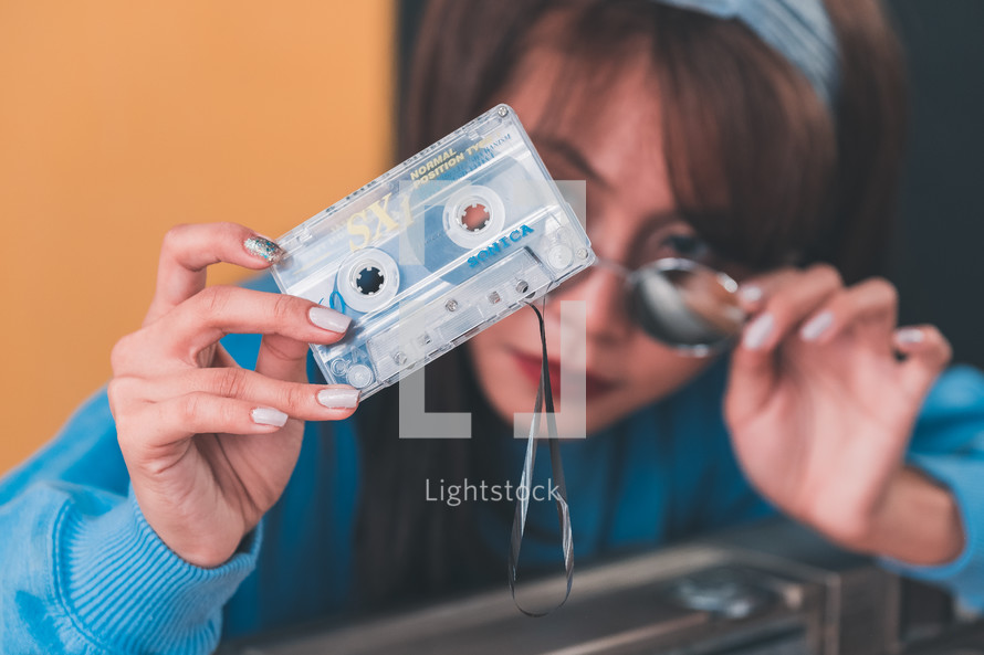 woman holding an old cassette tape 