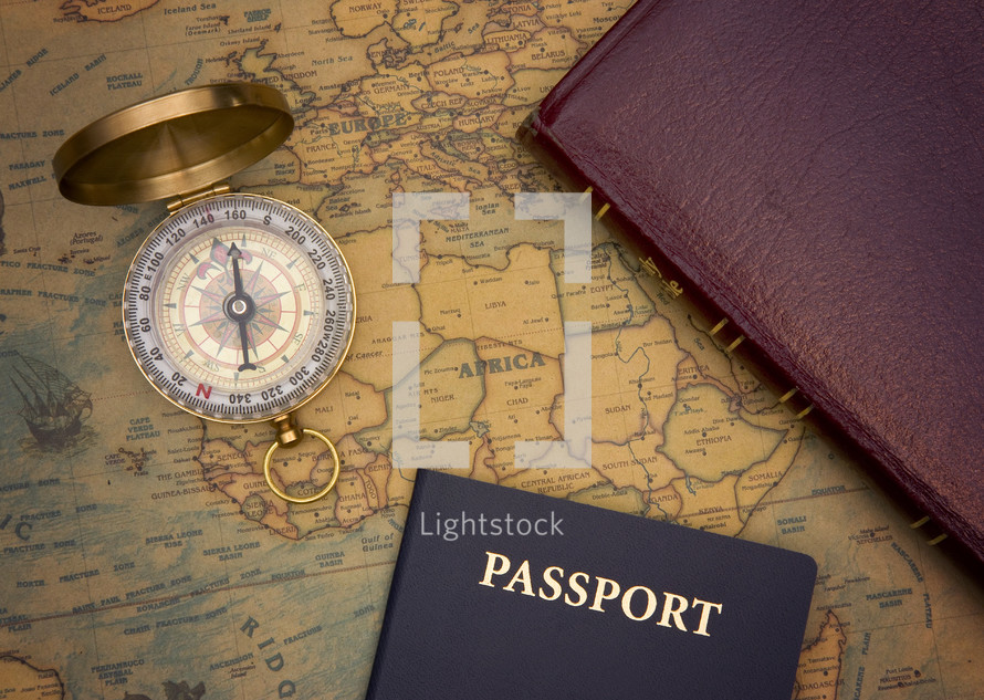 compass, Bible, and passport on a world map 