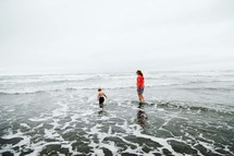 mother and child walking in the ocean 