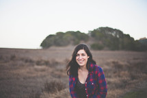 Smiling woman standing in a field.