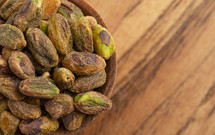 Roasted and Salted Pistachios without Shells on a Wood Table