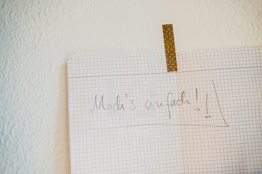 Graph paper with a message taped to a wall 