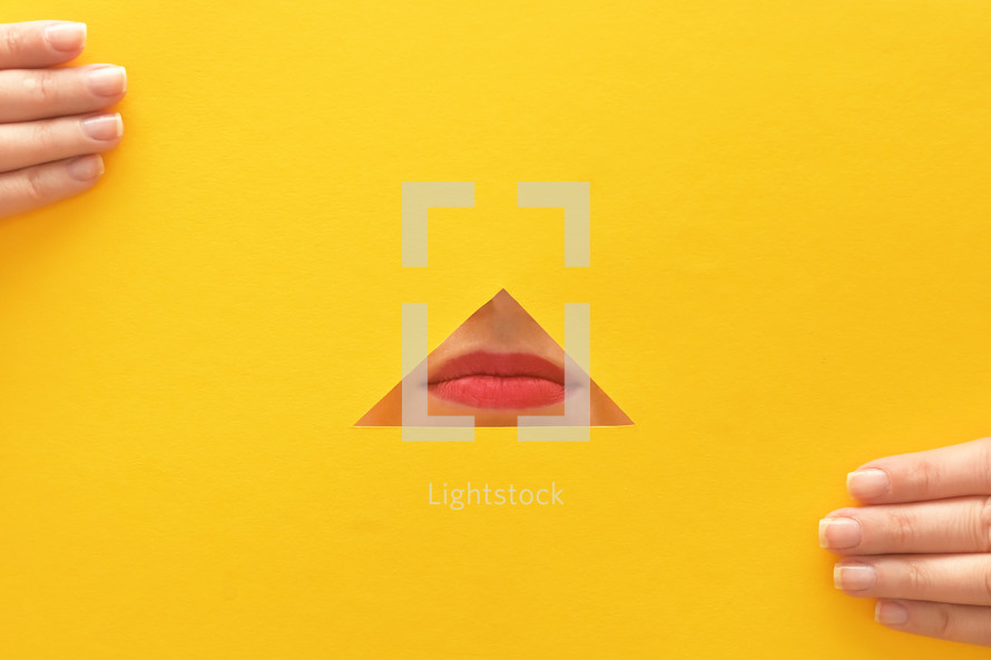 a woman's lips through a yellow piece of paper 