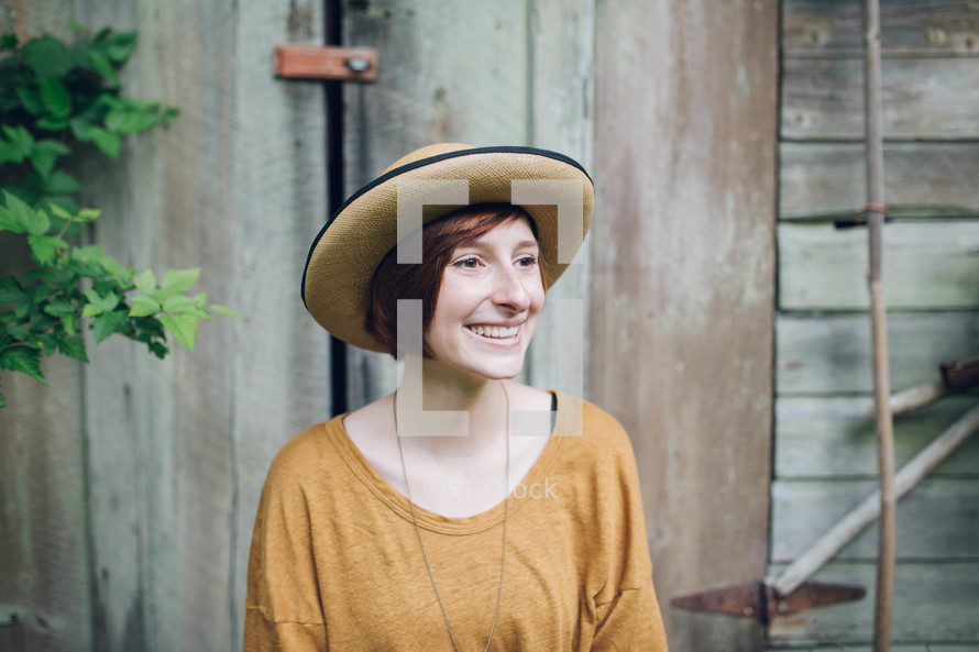 a smiling woman in a straw hat 