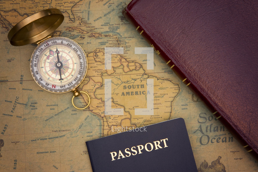 passport, compass, and Bible on a world map 