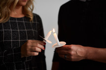 a man and woman holding a candle 