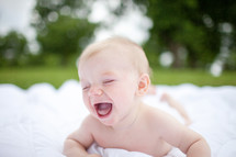 naked baby on a blanket outdoors