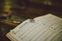 Wedding rings on pages of hymnal open to "Come, Thou Fount."