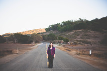 Woman standing in the middle of the road.